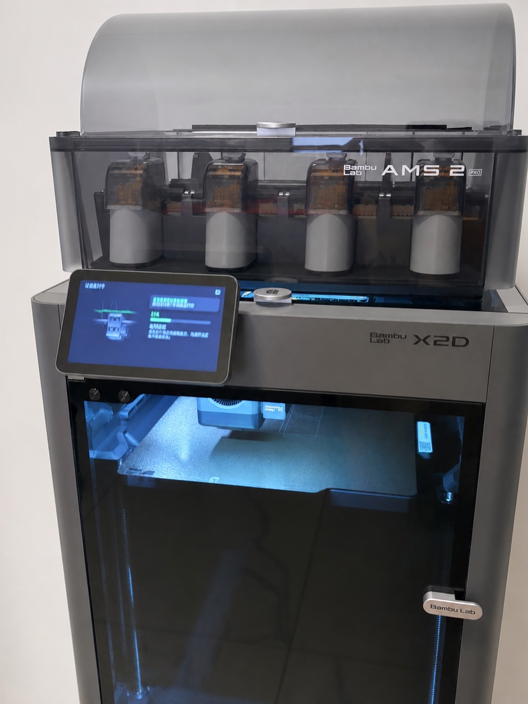 AI-retouched front photograph of our Bambu Lab X2D with the AMS 2 Pro lid open.